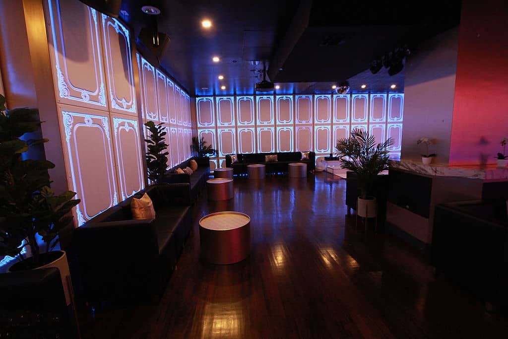 An interior view of a modern, dimly lit lounge with futuristic decorations and seating arrangements.